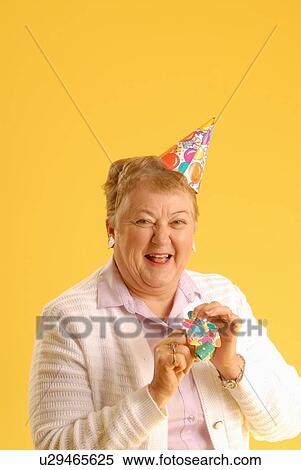 Stock Photography - Senior Woman party hat, Regina, Saskatchewan. Fotosearch