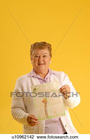 Stock Image - Senior Woman with letter; Canada, Saskatchewan, Regina. Fotosearch
