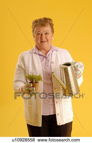 Stock Photo - Senior Woman with plants, Regina, Saskatchewan. Fotosearch