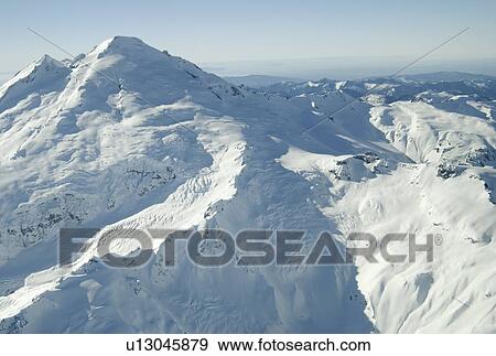 Stock Photo - Aerial photo of a dormant snowcapped volcano, Mount Baker, Washington, USA. Fotosearch