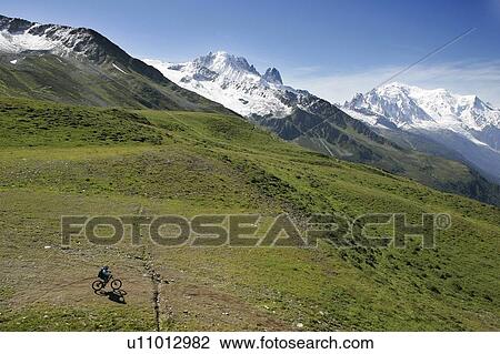 Stock Image - Mountain bike in front of The Mont Blanc, Les Drus and La Verte(left). Fotosearch
