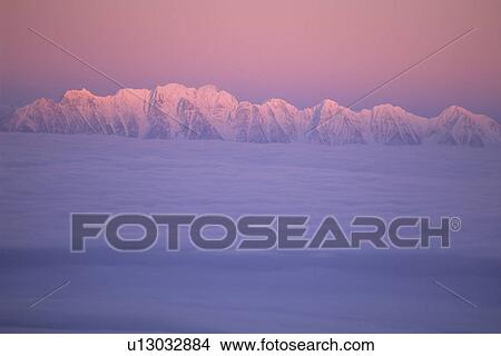 Picture - Mountain ridge called the Steeples in evening light with cloud inversion, East Kootenays, B. C.. Fotosearch