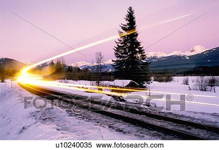 Train light shows speed along winter train tracks, alpenglow behind, Whistler, BC View Large Photo Image Stock Photography - Train light shows speed along winter train tracks, alpenglow behind, Whistler, BC. Fotosearch