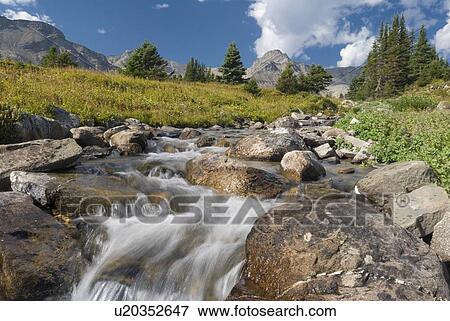 Stock Photo - A waterfall flows through an alpine meadow, Skyline Trail, Jasper National Park, Alberta, Canada. Fotosearch