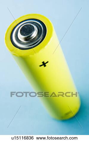 Stock Photograph - A Yellow Battery Against A Blue Background. Fotosearch