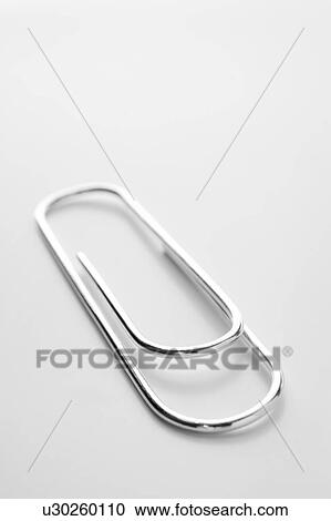 Stock Image - Close Up Of Silver Paperclip Against A White Background. Fotosearch