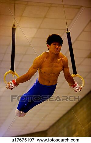 Young man practicing gymnastic rings View Large Photo Image Stock Photo - Young man practicing gymnastic rings. Fotosearch