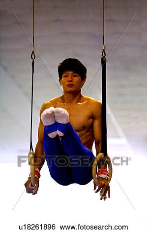 Young man practicing gymnastic rings View Large Photo Image Stock Photograph - Young man practicing gymnastic rings. Fotosearch