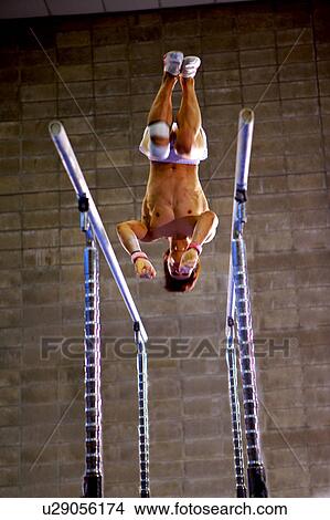 Picture - Young man practicing gymnastics on the parallel bars. Fotosearch