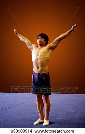 Picture - Young man practicing gymnastics on the floor. Fotosearch