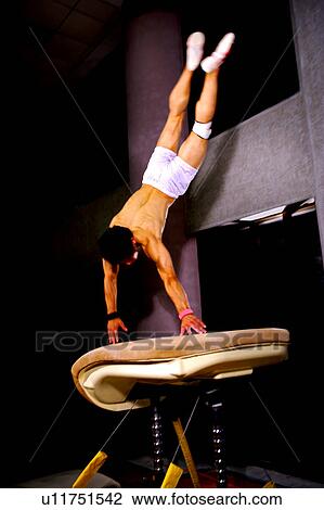Young man practicing gymnastics on the vaulting horse View Large Photo Image Stock Image - Young man practicing gymnastics on the vaulting horse. Fotosearch