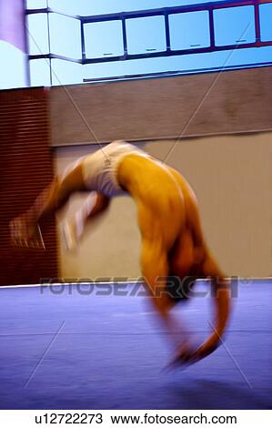 Young man practicing gymnastics on the floor View Large Photo Image Stock Image - Young man practicing gymnastics on the floor. Fotosearch