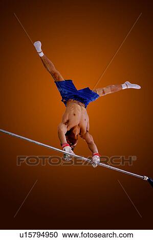Young man practicing gymnastics on the horizontal bar View Large Photo Image Stock Image - Young man practicing gymnastics on the horizontal bar. Fotosearch