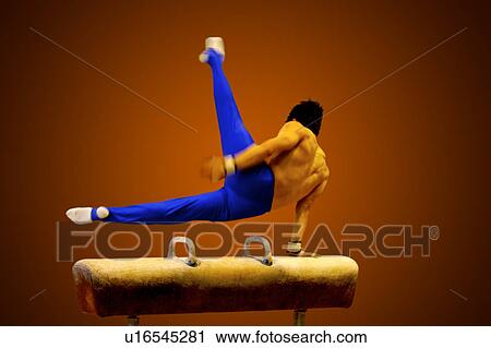 Young man practicing gymnastics on the pommel horse View Large Photo Image Stock Image - Young man practicing gymnastics on the pommel horse. Fotosearch