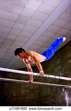 Young man practicing gymnastics on the parallel bars View Large Photo Image Stock Image - Young man practicing gymnastics on the parallel bars. Fotosearch