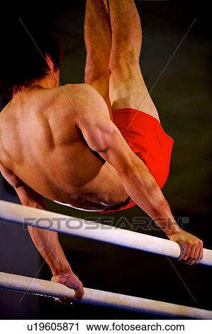Young man practicing gymnastics on the parallel bars View Large Photo Image Stock Image - Young man practicing gymnastics on the parallel bars. Fotosearch
