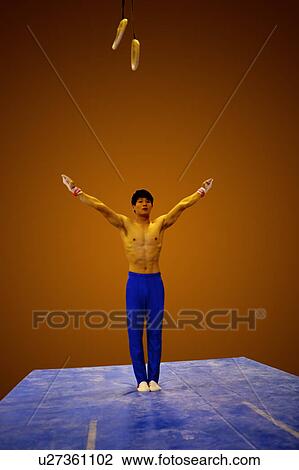 Young man practicing gymnastics on the floor, front view View Large Photo Image Stock Image - Young man practicing gymnastics on the floor, front view. Fotosearch