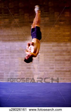 Young man practicing gymnastics on the floor View Large Photo Image Stock Image - Young man practicing gymnastics on the floor. Fotosearch
