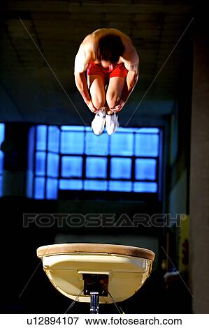 Young man practicing gymnastics on the vaulting horse View Large Photo Image Stock Photo - Young man practicing gymnastics on the vaulting horse. Fotosearch