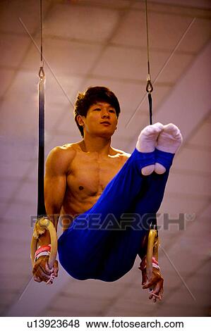 Young man practicing gymnastics on the gymnastic rings View Large Photo Image Stock Photo - Young man practicing gymnastics on the gymnastic rings. Fotosearch