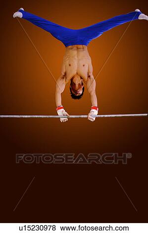 Young man practicing gymnastics on the horizontal bar View Large Photo Image Stock Photo - Young man practicing gymnastics on the horizontal bar. Fotosearch