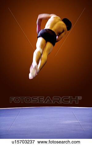 Stock Photo - Young man practicing gymnastics on the floor. Fotosearch