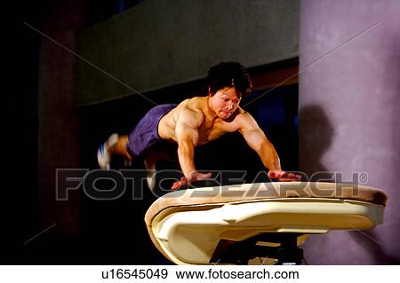 Young man practicing gymnastics on the vaulting horse View Large Photo Image Stock Photo - Young man practicing gymnastics on the vaulting horse. Fotosearch
