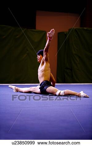Young man practicing gymnastics on the floor View Large Photo Image Stock Photo - Young man practicing gymnastics on the floor. Fotosearch