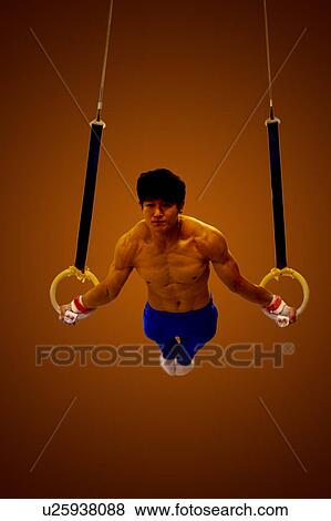 Young man practicing gymnastics on the gymnastic rings View Large Photo Image Stock Photo - Young man practicing gymnastics on the gymnastic rings. Fotosearch