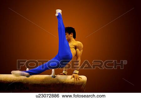 Stock Photograph - Young man practicing gymnastics on the pommel horse. Fotosearch