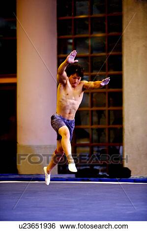 Stock Photograph - Young man practicing gymnastics on the floor. Fotosearch