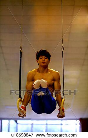 Young man practicing on the gymnastic rings View Large Photo Image Stock Photo - Young man practicing on the gymnastic rings. Fotosearch