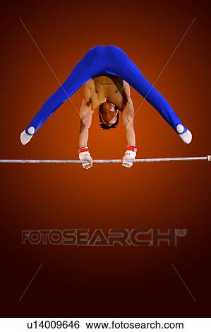 Stock Photograph - Young man practicing on the horizontal bar. Fotosearch