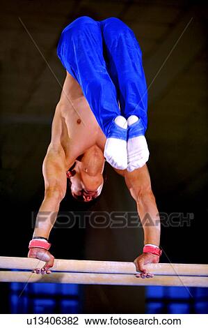 Young man practicing on the parallel bars View Large Photo Image Stock Image - Young man practicing on the parallel bars. Fotosearch