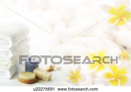 Clip Art - Candle, soap, hairbrush and folded towels with frangipanis in background (composite). Fotosearch
