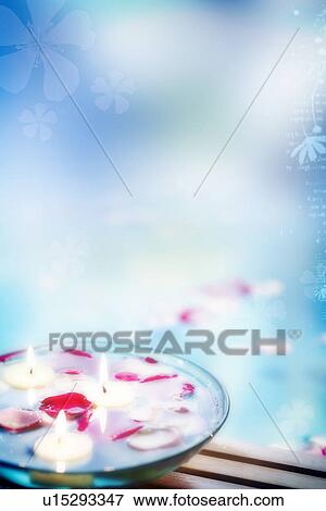 Stock Illustration - Lit candles and petals in a plate on a bench (composite). Fotosearch