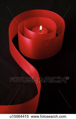 Stock Photography - Close-up of a candle in the red ribbon. Fotosearch