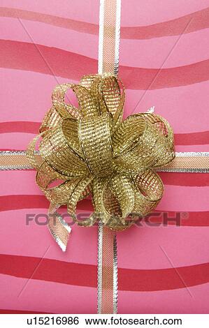 Close-up of a golden tied knot on the wrapping paper View Large Photo Image Stock Photograph - Close-up of a golden tied knot on the wrapping paper. Fotosearch