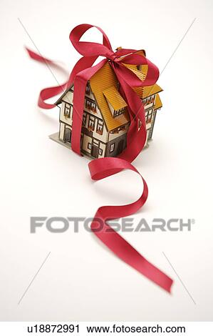 Stock Image - Close-up of a house model with a red ribbon. Fotosearch