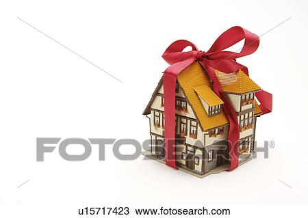 Stock Image - Close-up of a house model with red ribbon. Fotosearch