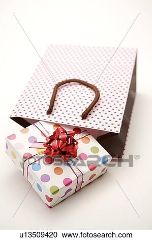 Close-up of a wrapped present and a shopping bag View Large Photo Image Stock Image - Close-up of a wrapped present and a shopping bag. Fotosearch