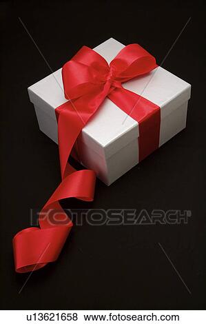 Close-up of a wrapped present with red ribbon View Large Photo Image Stock Photo - Close-up of a wrapped present with red ribbon. Fotosearch