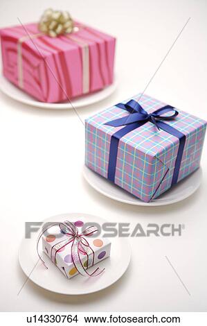 Picture - Close-up of three wrapped presents on the plate. Fotosearch