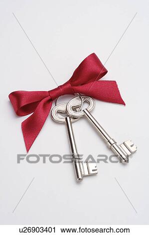Stock Image - Close-up of two keys with a red bowknot. Fotosearch