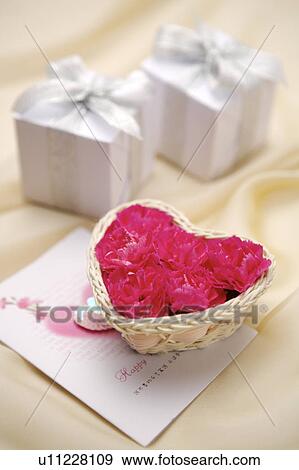 Stock Photo - Close-up of wrapped gifts, a small basket of flowers and a greeting card. Fotosearch