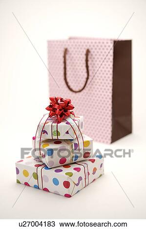 Three wrapped gifts and a shopping bag View Large Photo Image Stock Image - Three wrapped gifts and a shopping bag. Fotosearch
