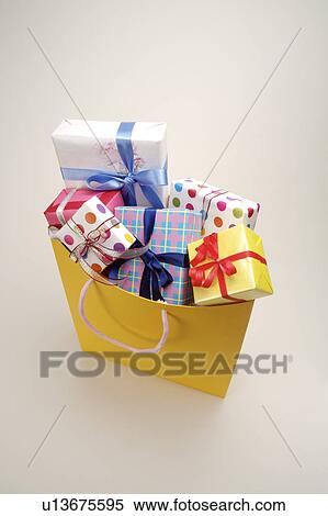 Wrapped gifts in a shopping bag View Large Photo Image Stock Photography - Wrapped gifts in a shopping bag. Fotosearch