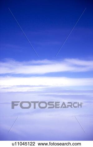 Stock Image - Clouds in the clear sky. Fotosearch