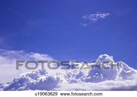 Stock Photo - Cumulus clouds in the clear sky. Fotosearch