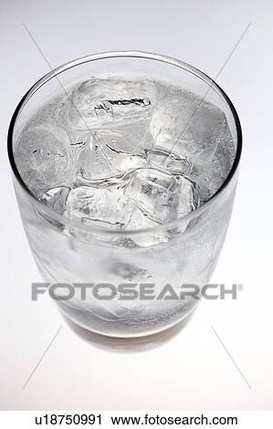Stock Image - Close-up of a glass of water with ice cubes. Fotosearch